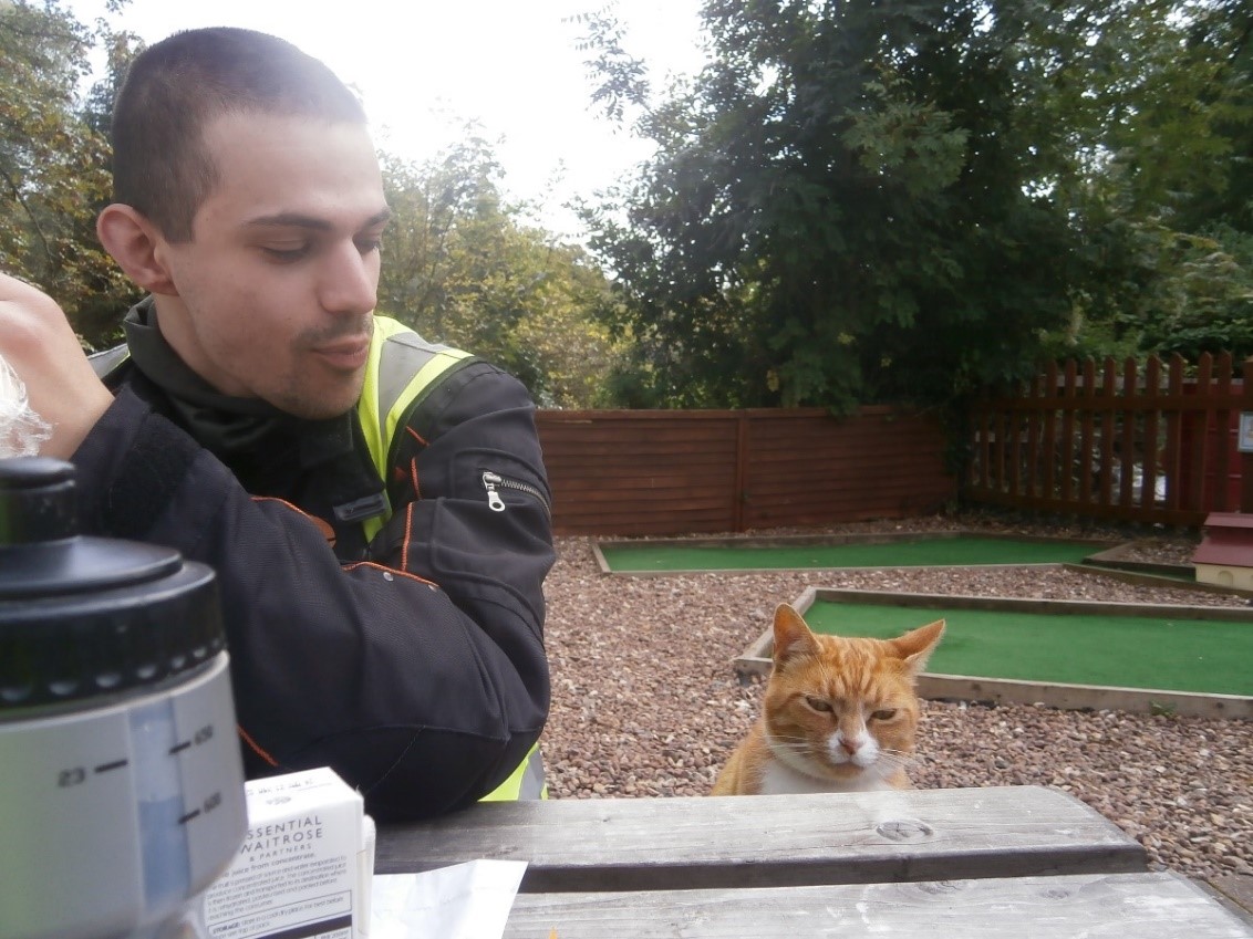 Photo of Luke eating lunch - with a cat eyeing it up