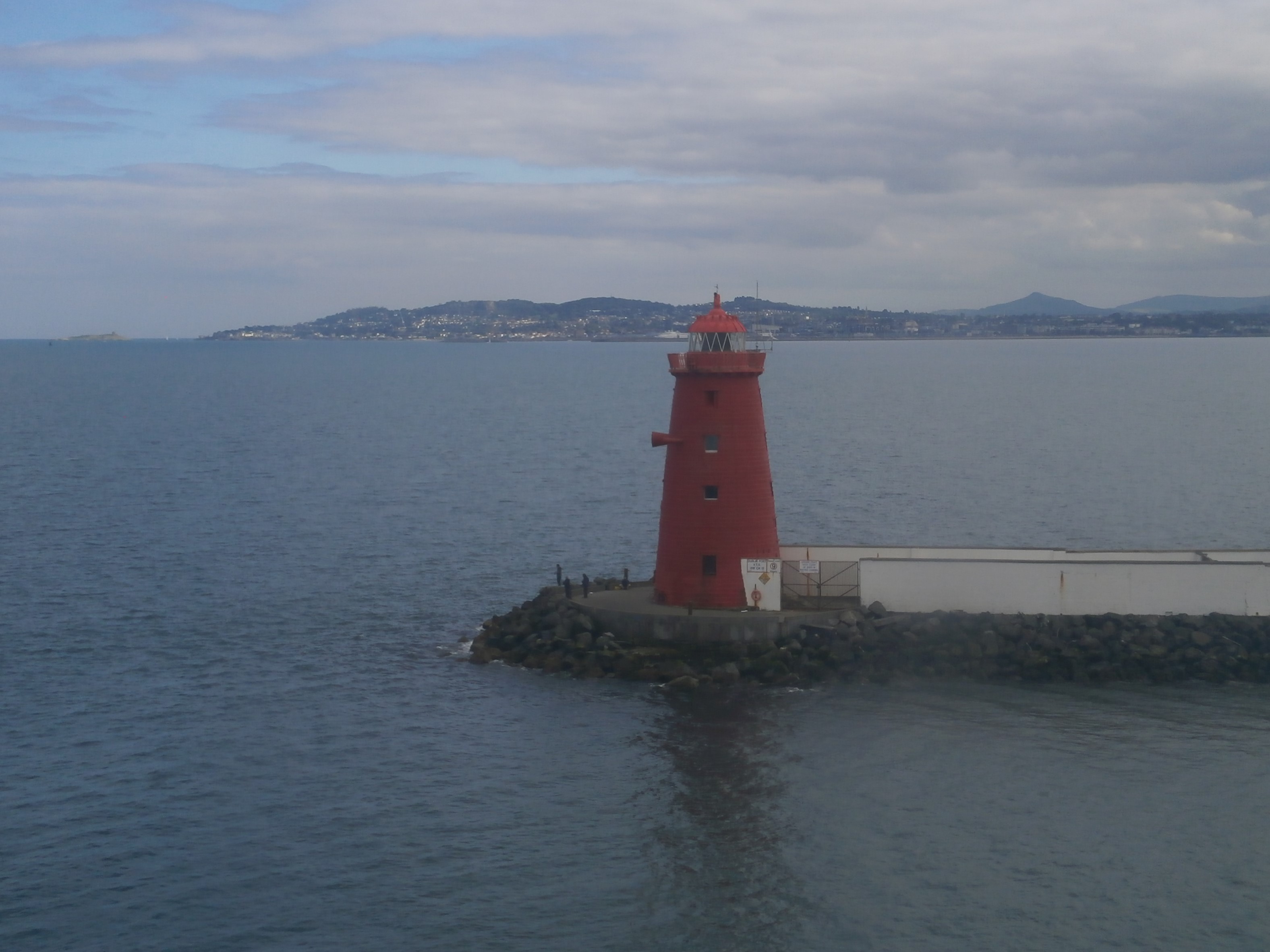 Photo, from ferry crossing, of a red lighthouse near Dublin