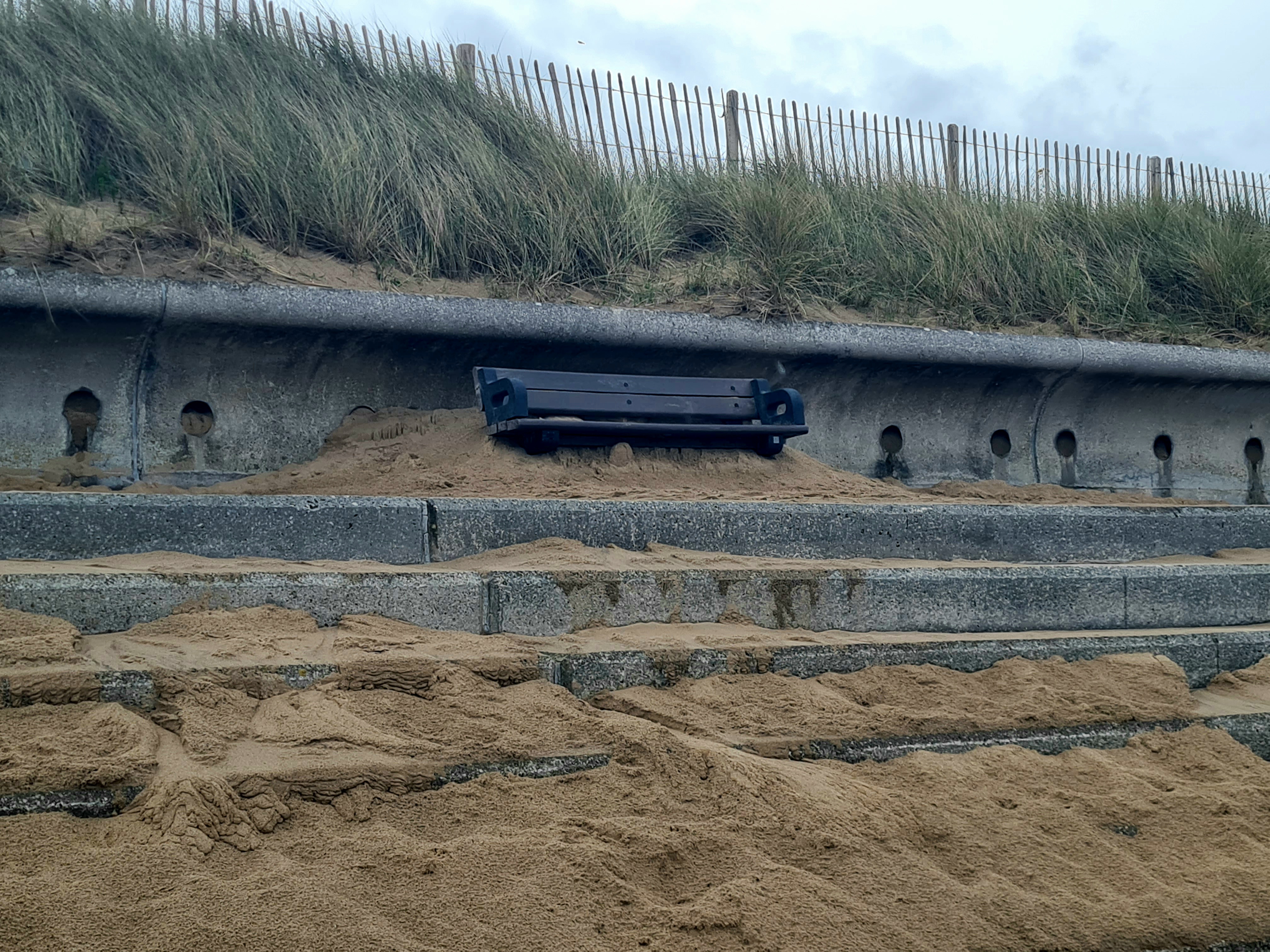 Photo of Sand all around bench on North Wales coastal path between Rhyl and Prestatyn